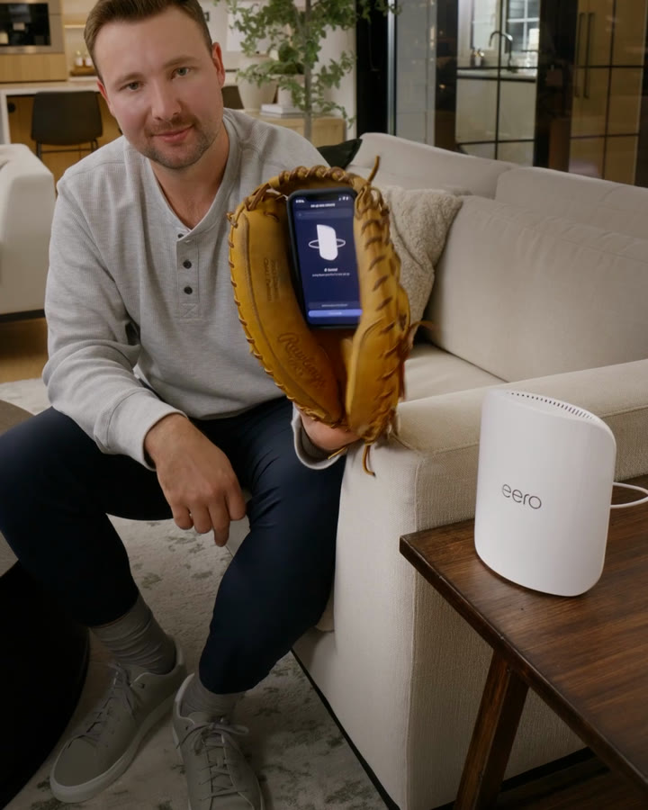 Cal Raleigh holding the phone in his catcher's mitt, the setup app on screen, in the finished spot